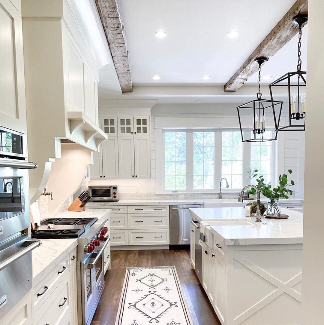 White Kitchen With Cane Stools and Patterned Tile