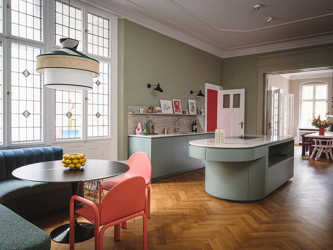 Luxurious kitchen featuring large rounded island and cool stools