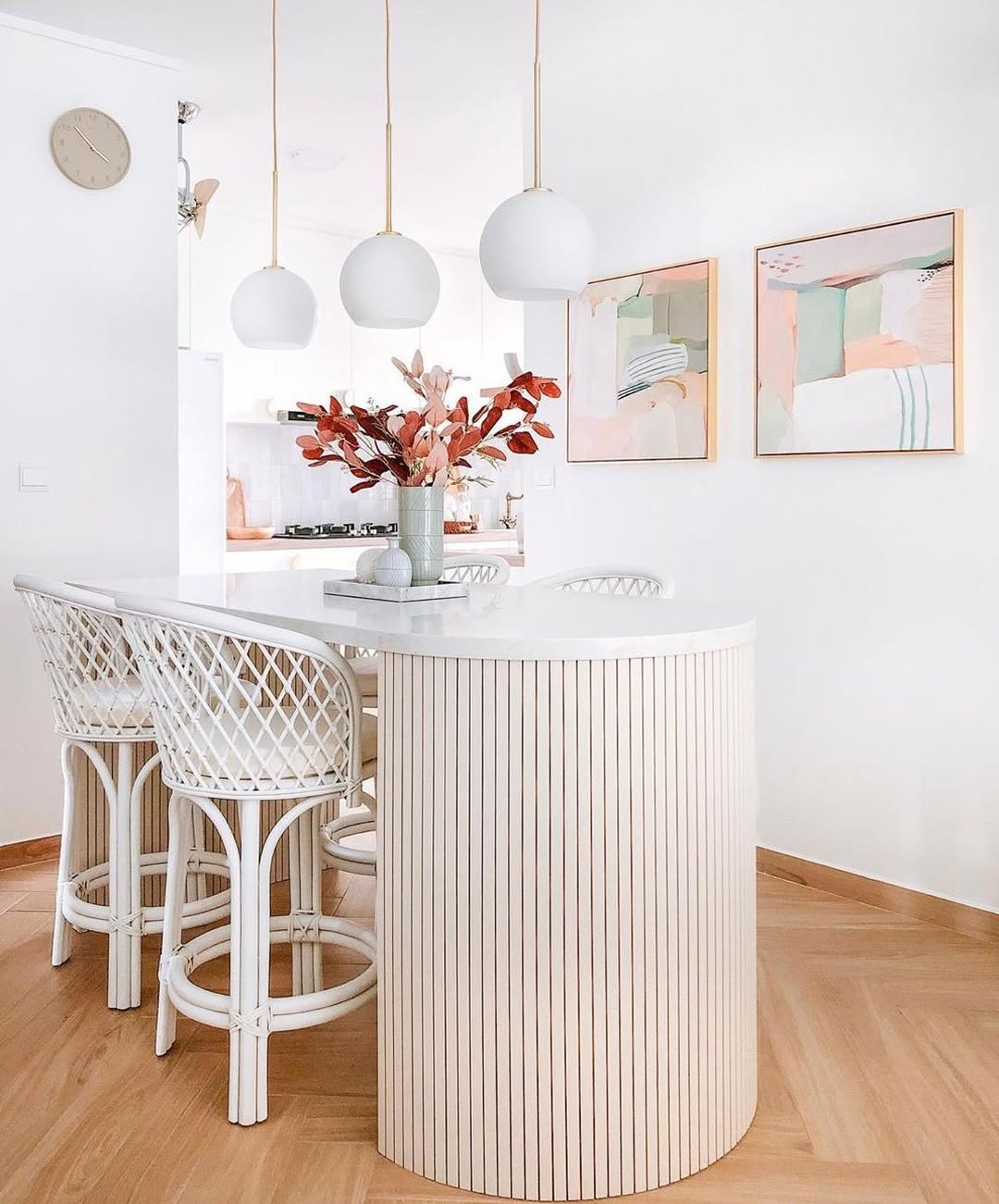 Luxurious kitchen featuring large rounded island and cool stools