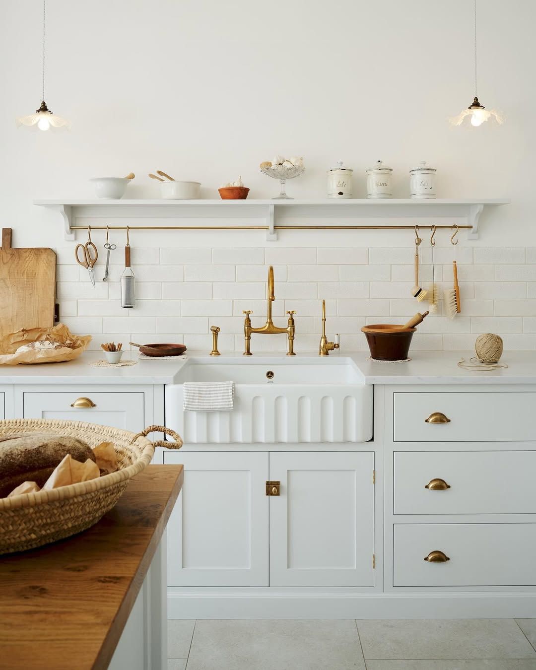 White Kitchen With Cane Stools and Patterned Tile