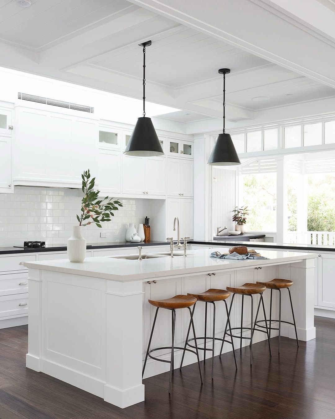 White Kitchen With Cane Stools and Patterned Tile