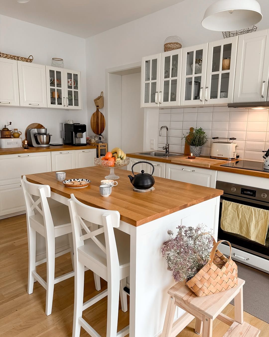White Kitchen With Cane Stools and Patterned Tile