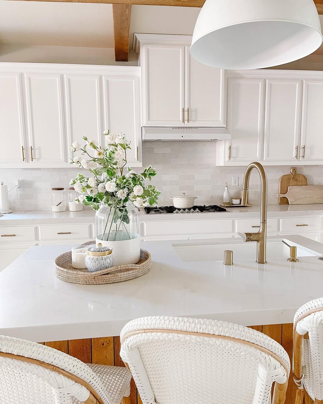 White Kitchen With Cane Stools and Patterned Tile