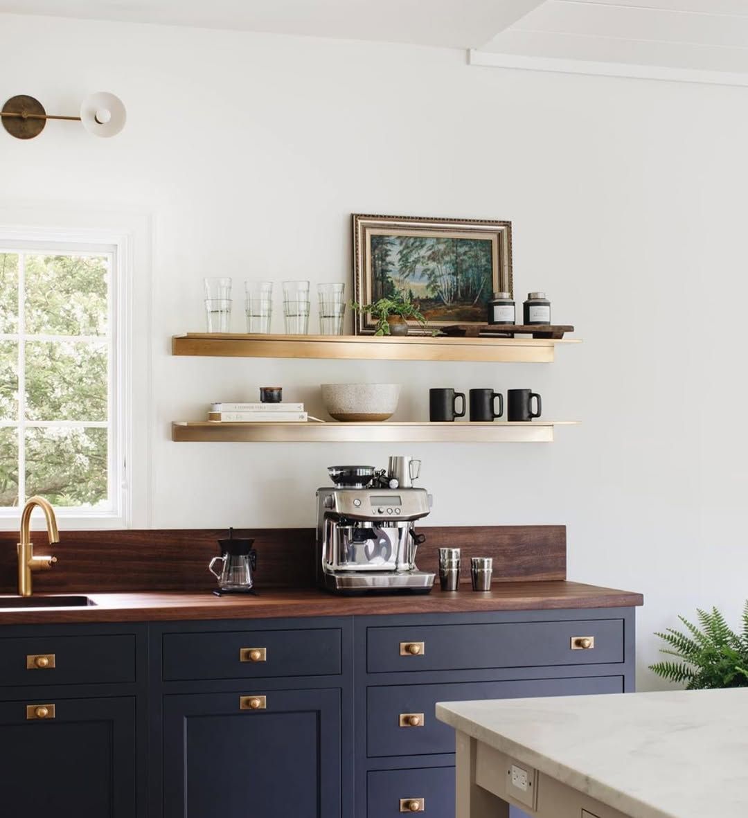 Brass shelving that holds its own against patterned tile