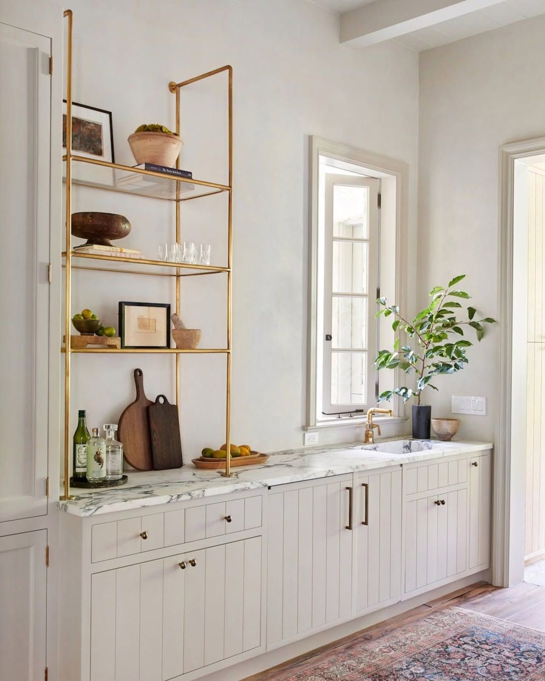 Brass shelving that holds its own against patterned tile