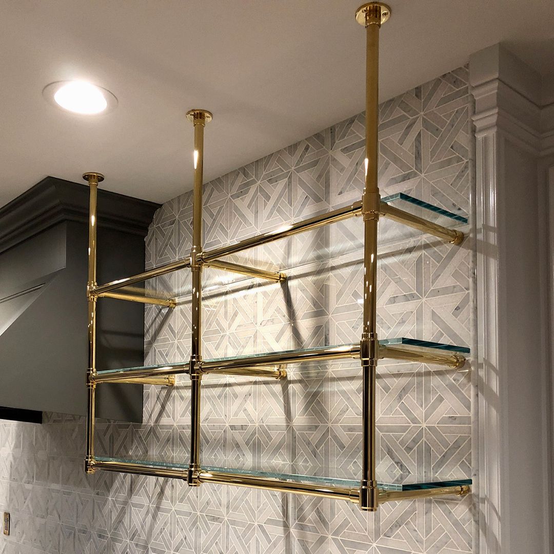 Brass shelving that holds its own against patterned tile