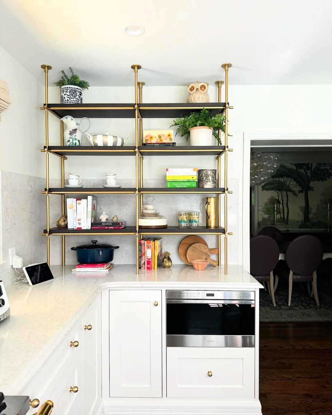 Brass shelving that holds its own against patterned tile