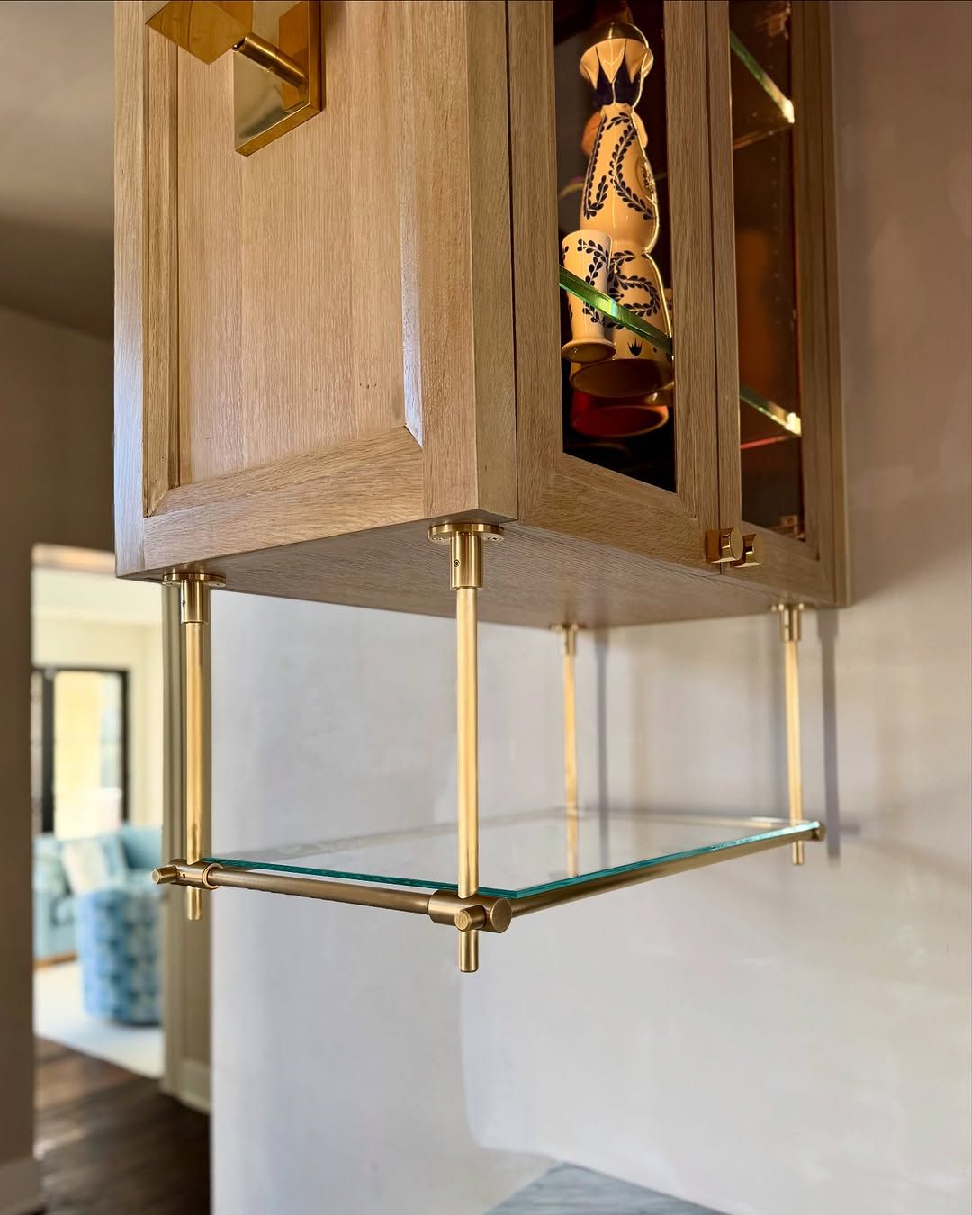 Brass shelving that holds its own against patterned tile