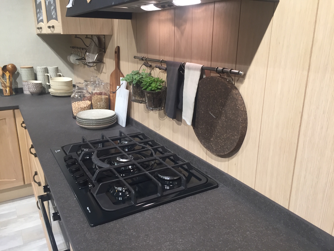 Vertical wall paneling with a minimal countertop rim What works here is how the wall and counter are treated as two separate decisions. The vertical paneling takes over the wall entirely, while the countertop ends with a small rim that handles splashes where they actually occur. There is no attempt to turn the backsplash into a visual element. The wall stays the wall. This changes how the kitchen reads as a whole. Instead of a horizontal strip cutting across the space, the vertical lines keep the surface continuous and uninterrupted. The countertop edge does its job quietly, without extending upward or asking for attention. In kitchens like this, a traditional backsplash would feel added later. This approach feels planned from the start, which is why I’m choosing it instead.